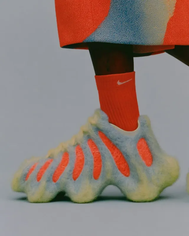 A close-up shot of an innovative sneaker design with a vibrant color palette. The image features a mix of soft textures and bold hues, creating a playful and surreal mood.
