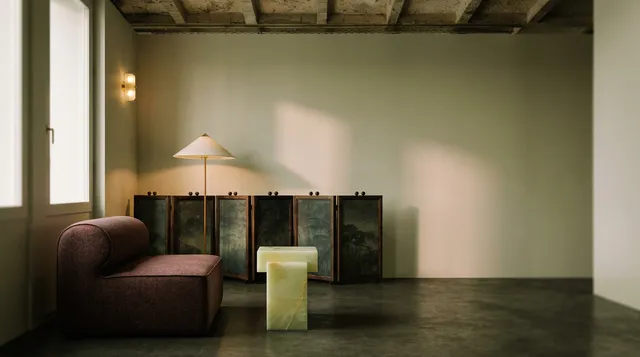 A serene interior scene featuring modern furniture with a muted color palette. The composition highlights a plush armchair and a unique side table, accented by soft natural lighting.